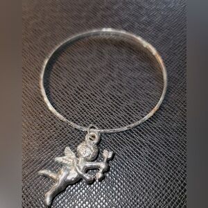 Silver tone bangle with Cupid charm.